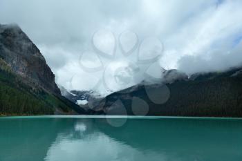 View of Turquoise waters of Lake Louise on a foggy day with dramatic sky, Alberta, Canada