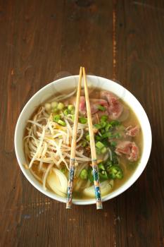 Asian noodle soup with beef, shives, onion, bean sprout and lime