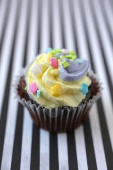  Yellow and lilac cupcake on a black and white lined background