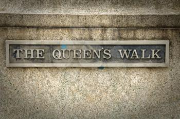 The queen's walk sign in London.  Queen's Walk takes you over Westminster Bridge, along the south bank of the River Thames towards over the river on the Millennium footbridge to St Paul's Cathedral