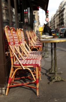 Red chairs and round table on the street in Paris, France.